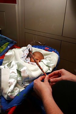 A mother performs a smudging ritual to cleanse her newborn baby.