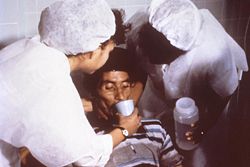 Nurses encourage patients to drink large amounts of an oral rehydration solution to counteract the massive dehydration resulting from cholera.