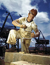 Carpenter using a crank-powered brace to drill a hole.