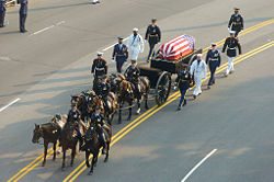 Members of a joint honor guard escort the caisson bearing President Ronald Reagan's flag-draped casket during his funeral procession