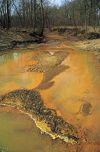 Iron hydroxide precipitate stains a stream receiving acid drainage from surface coal mining