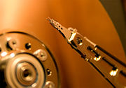An IBM HDD head suspended above the disk platter.
