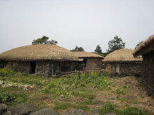 Traditional Jeju houses, with their unique style of thatching, tied down to protect against ocean winds.