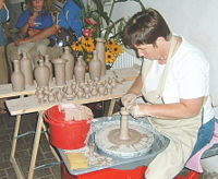 An artisan throwing pots on an electric potters wheel