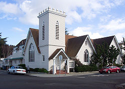 Carpenter gothic Unitarian Universalists of San Mateo, California (built 1905) showing gothic arches, steep gables, and a tower. The tower includes examples of abat-sons.