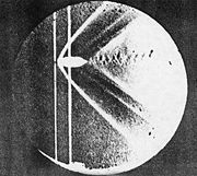 Shadowgraph of the detached shock on a bullet in supersonic flight, published by Ernst Mach in 1887.