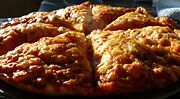 Cooked from frozen pizza topped with cheese and tomato sauce