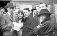 D.W. Griffith on a movie set with actor Henry Walthall and others.