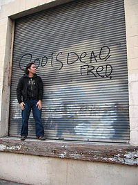 Loading dock graffiti proclaims "God Is Dead, Fred"