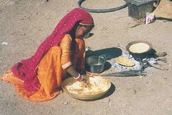 A girl from the Gadia Lohars nomadic tribe of Marwar, cooking on the outskirts of a village in Ratlam district.