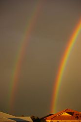 A double rainbow features reversed colors in the outer (secondary) bow, with the dark Alexander's band between the bows.