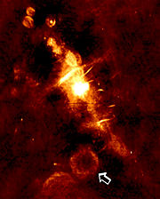 A radio image of the central region of the Milky Way galaxy. The arrow indicates a supernova remnant which is the location of a newly-discovered transient, bursting low-frequency radio source GCRT J1745-3009.