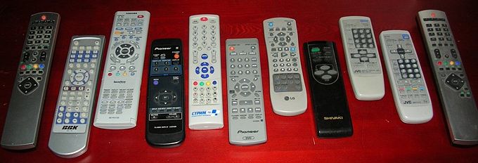 An assortment of remote controls for TV, VHS, and DVD devices.
