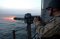 A 7.62 mm GAU-17 Gatling gun of the U.S. Navy. It is an externally powered automatic machine gun. The electric motor that powers its loading, priming, and firing mechanics is on top. Also, note the spade grips and pintle mount.