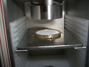 Alpha source beneath a radiation detector.