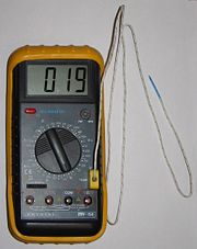 Thermocouple plugged to a multimeter displaying room temperature in °C.