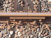 Bolted rail connection and tie-down. Also known as a fishplate.