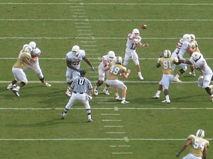 A quarterback attempts a forward pass.