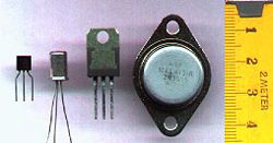 Through-hole transistors (tape measure marked in centimetres)