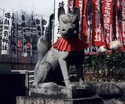 Statue of a kitsune adorned with a red votive bib in a shrine at Inuyama Castle. Many castles in Japan contain Inari shrines.