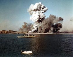 Hungnam is blown up as USS Begor stands by, Dec. 24, 1950